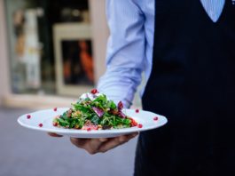 Un camarero sirve un plato de comida en una foto de archivo.