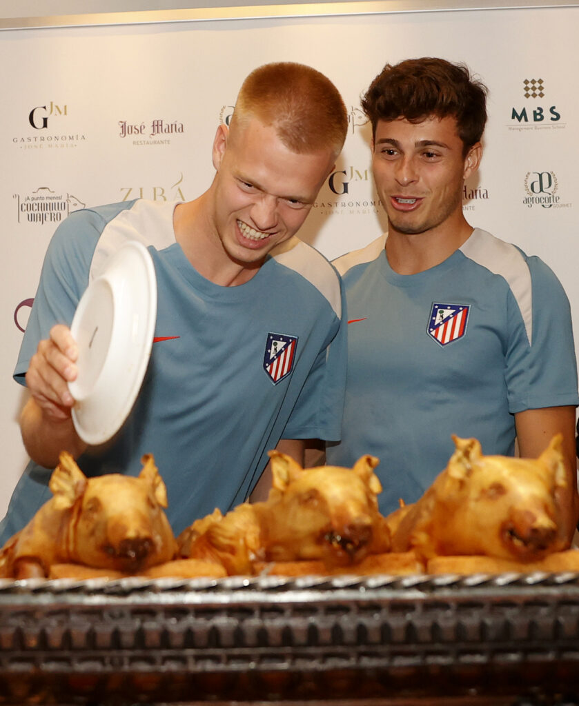Los jugadores Rodrigo Riguelme y Arthur Vermeer cortan el cochinillo con el plato