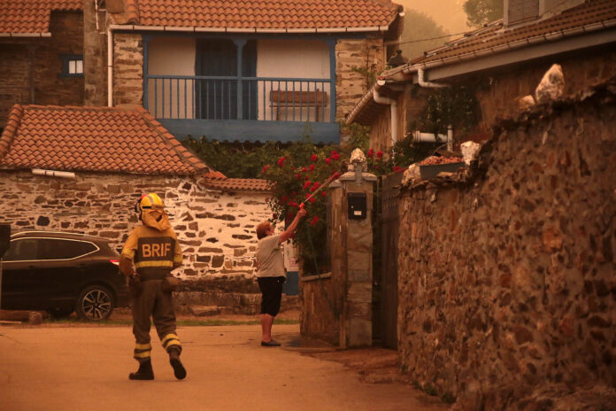 Vecinos y personal forestal de Busnadiego y Piedras Albas (Lucillo, León) se afanan intentando parar el incendio que amenaza los pueblos Fotografía Ical. Desalojos en León