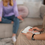 Vista lateral de una joven hablando con su terapeuta