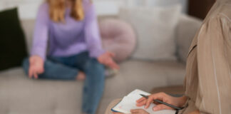 Vista lateral de una joven hablando con su terapeuta