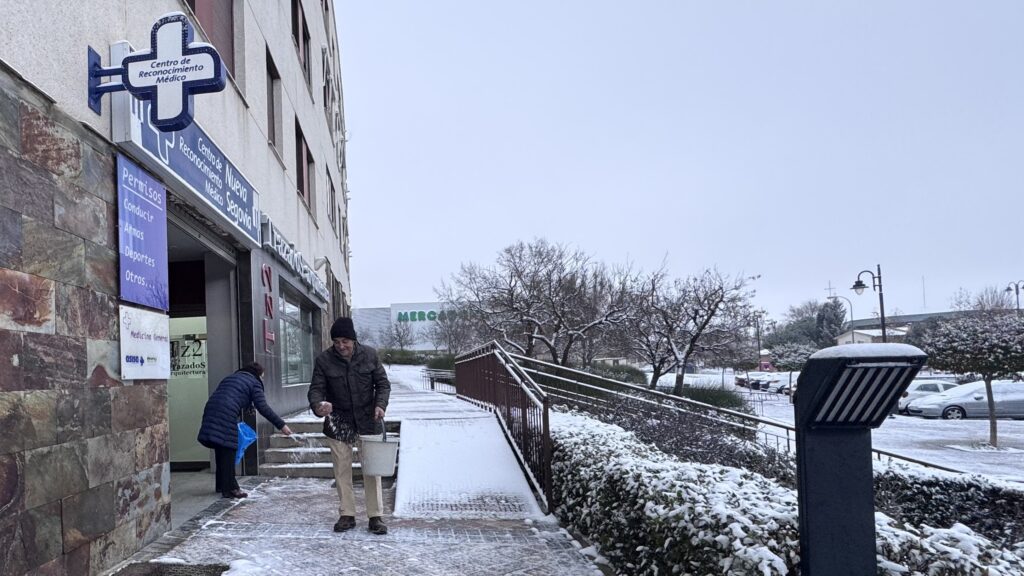 Vecinos con sal para proteger del hielo. Segoviaudaz.es