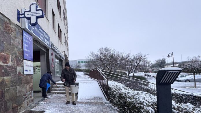 Vecinos con sal para proteger del hielo. Segoviaudaz.es
