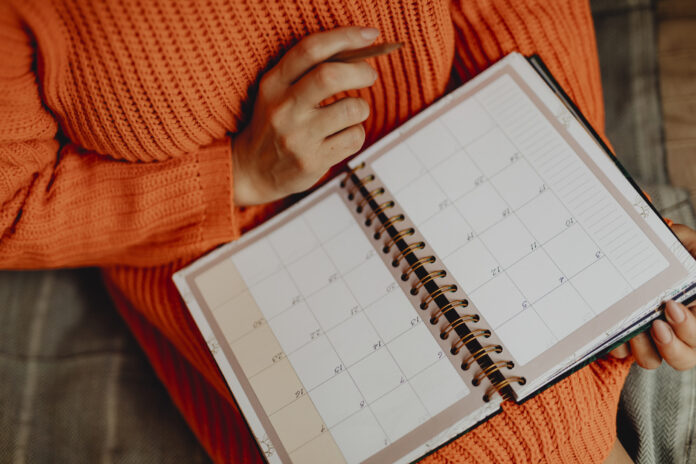 Woman writing on her daily planner